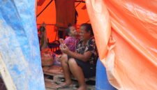 Seorang ibu dan anak memanfaatkan layanan telekomunikasi pascabencana di Sumatra. Foto:Telkom